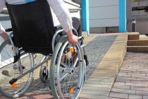 Person in wheelchair going up a ramp to their house